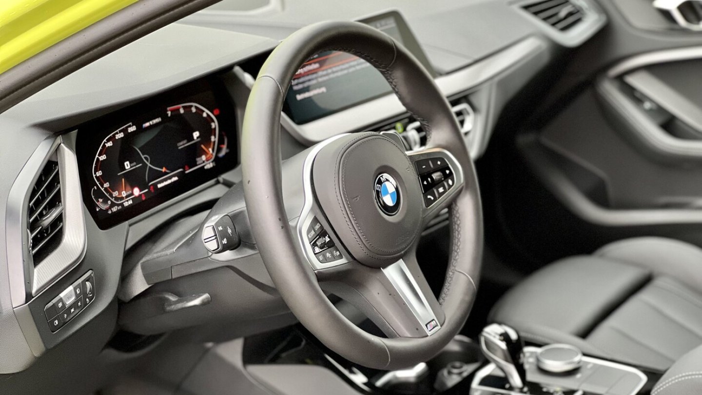 Auf der Mittelkonsole des M135i xDrive greift die Hand zum iDrive-Controller. Auf der Mittelkonsole des M135i xDrive greift die Hand zum iDrive-Controller.