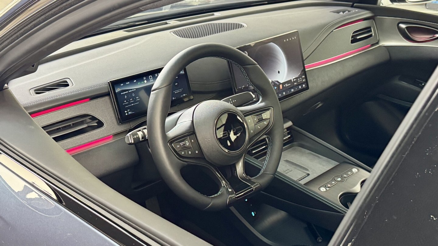 Das Ambientelicht zieht sich wellenförmig über das Armaurenbrett. Im Bild der Seal 6 Comfort Lite mit 12,8 Zoll großem Display.