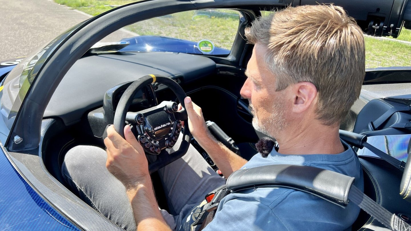 Sieht seltsam aus, passt aber zum Fahren ganz gut. Großer Mensch im engen Auto. Sieht seltsam aus, passt aber zum Fahren ganz gut. Großer Mensch im engen Auto.