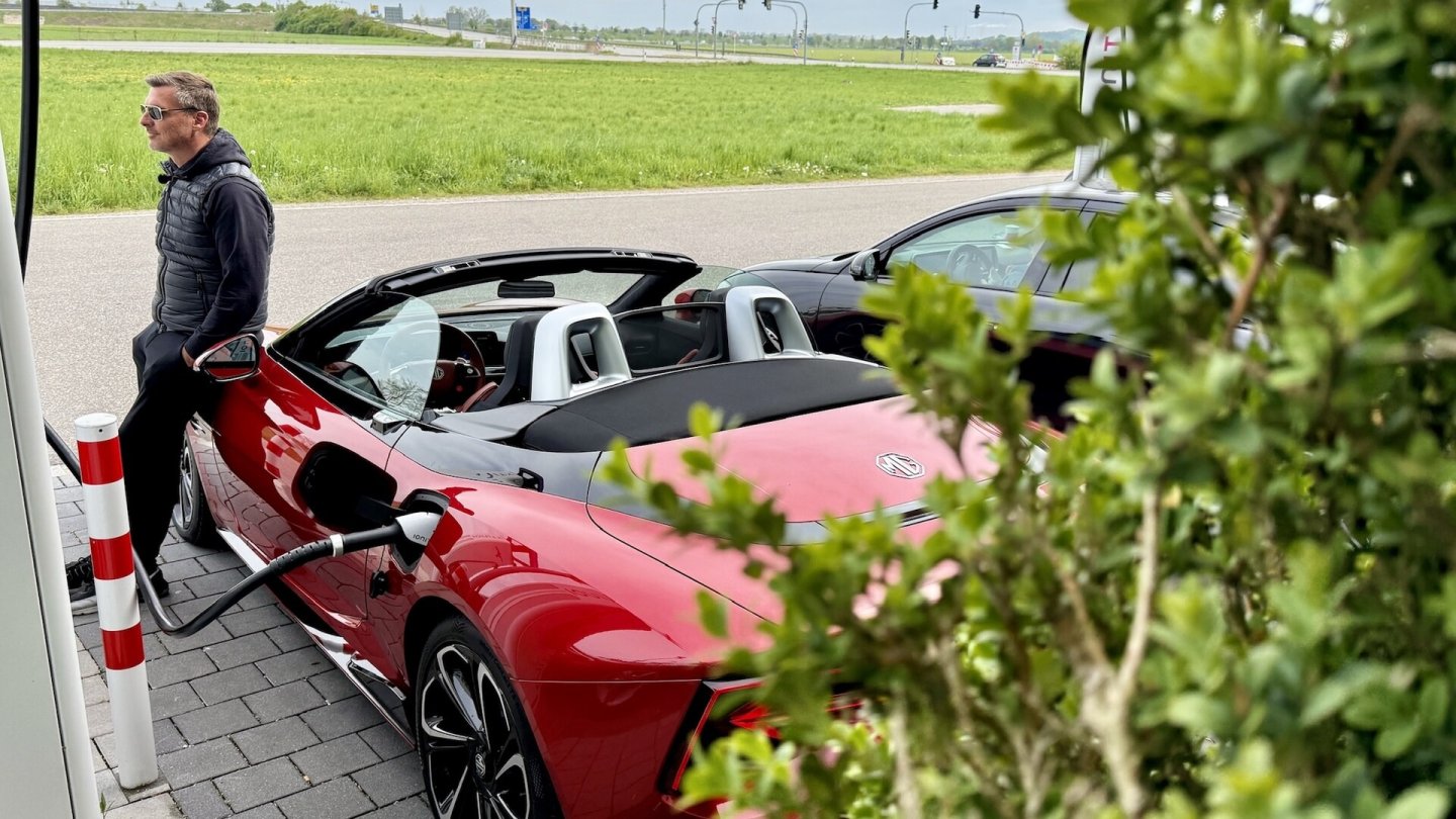 Solist zwischen all den SUV und Limousinen: Ein offener Sportwagen am Schnelllader. Solist zwischen all den SUV und Limousinen: Ein offener Sportwagen am Schnelllader.