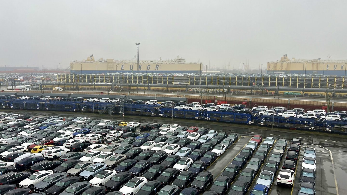 Neuwagen werden auch per Zug an- und abtransportiert. Im Hintergrund ein RoRo-Frachter. Neuwagen werden auch per Zug an- und abtransportiert. Im Hintergrund ein RoRo-Frachter.
